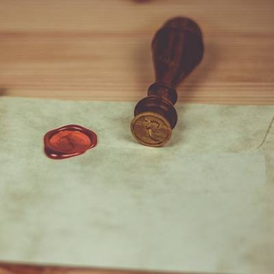 Cachet en cire rouge sur table en bois.